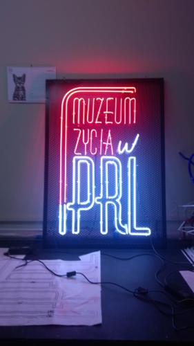 muzeum życia w PRL - neon podświetlony po obrysie liter